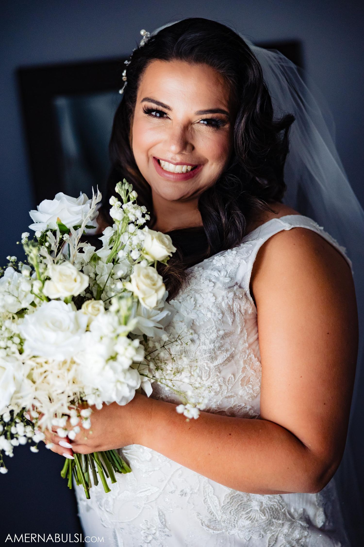 Elegant bridal portrait with white floral bouquet and lace dress.