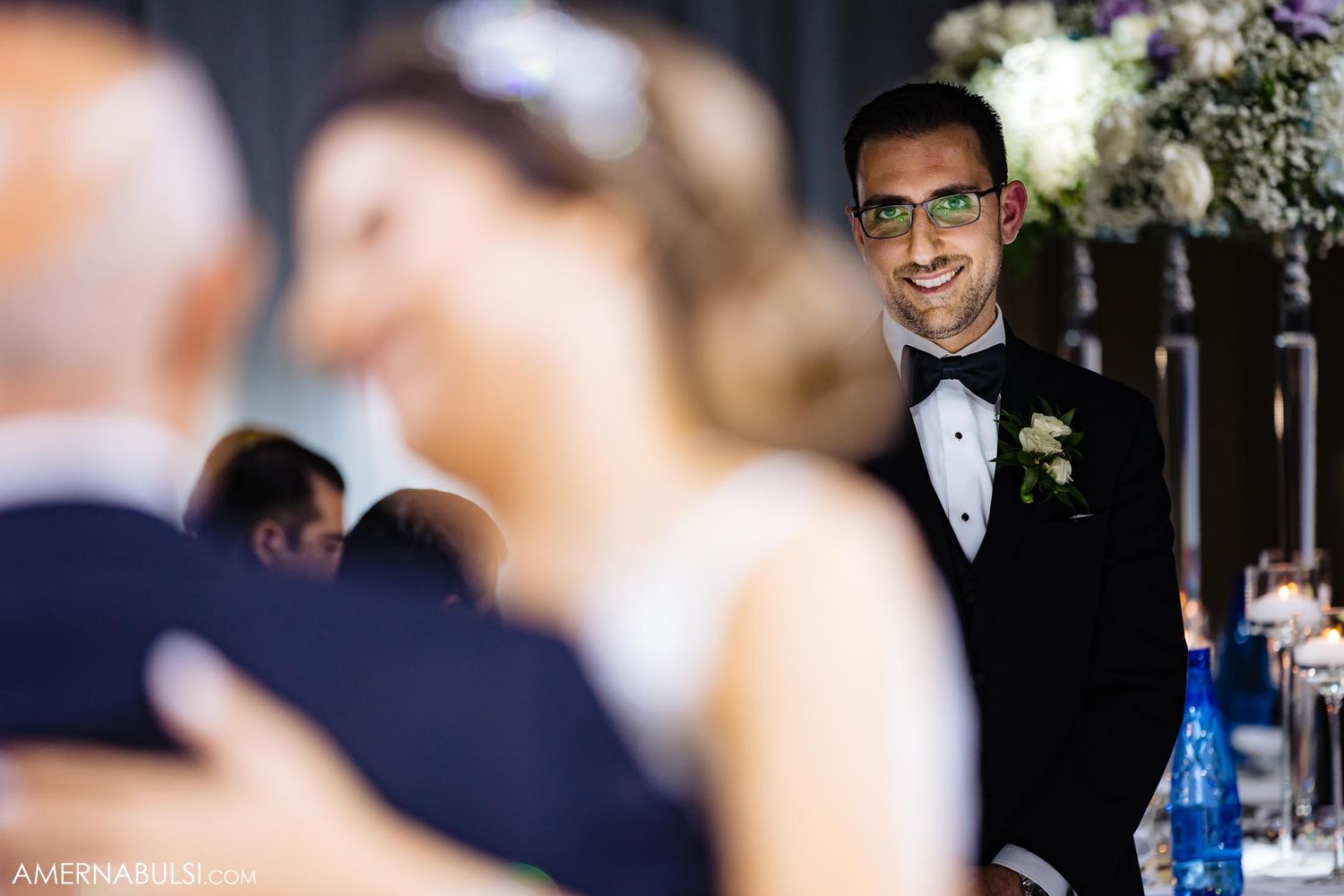 A joyful smile during an elegant black-tie wedding celebration.