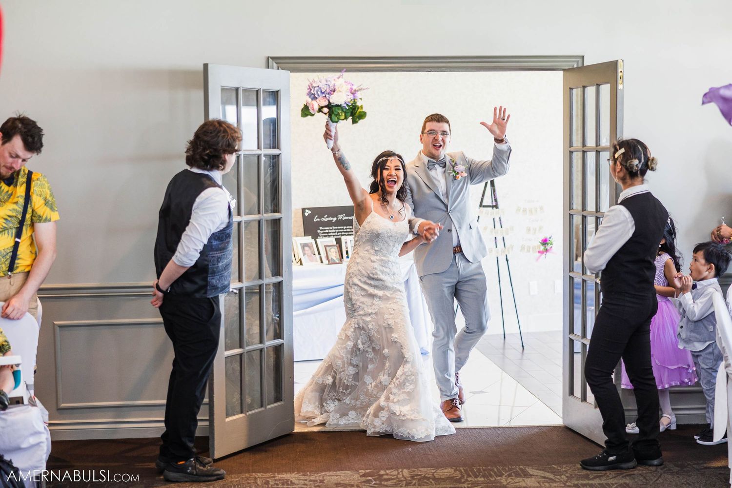 A joyful grand entrance through double doors at a wedding reception venue.