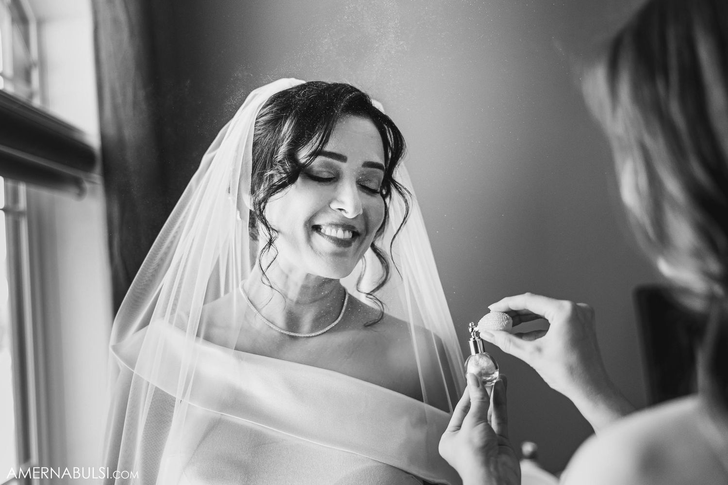 Black and white portrait of bride getting ready with joyful expression.