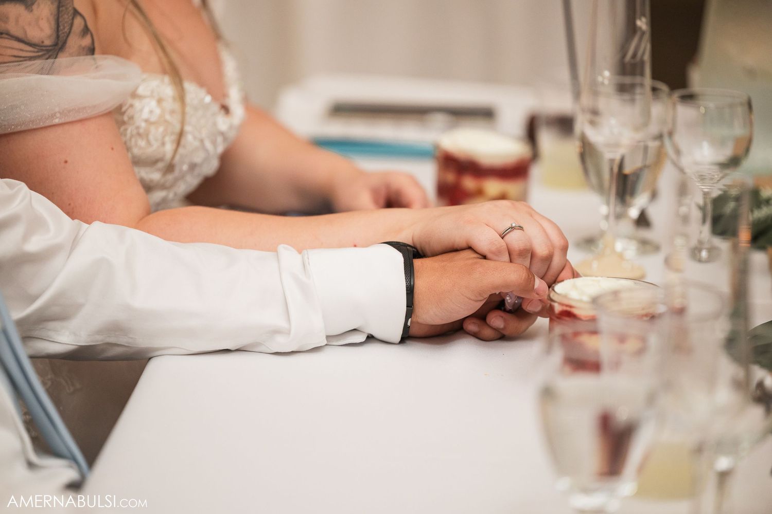 Close-up details of wedding table settings with wine glasses and place settings.