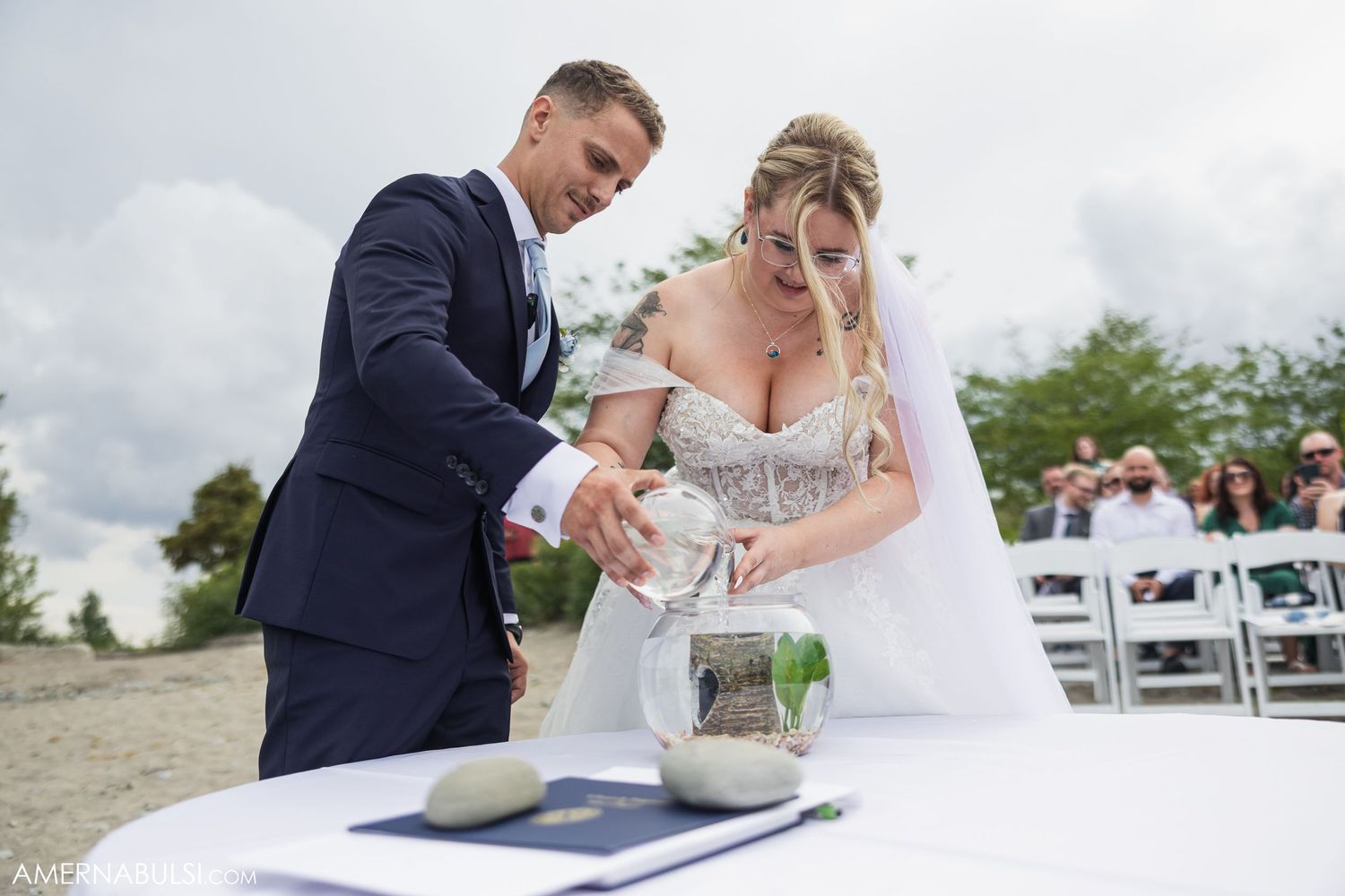 A couple signing their marriage certificate during an outdoor wedding ceremony.