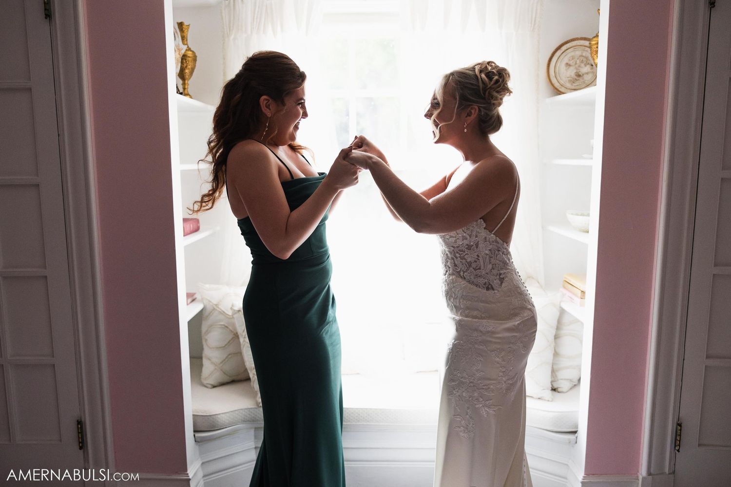 Wedding preparation scene with two people in formal attire helping each other get ready.