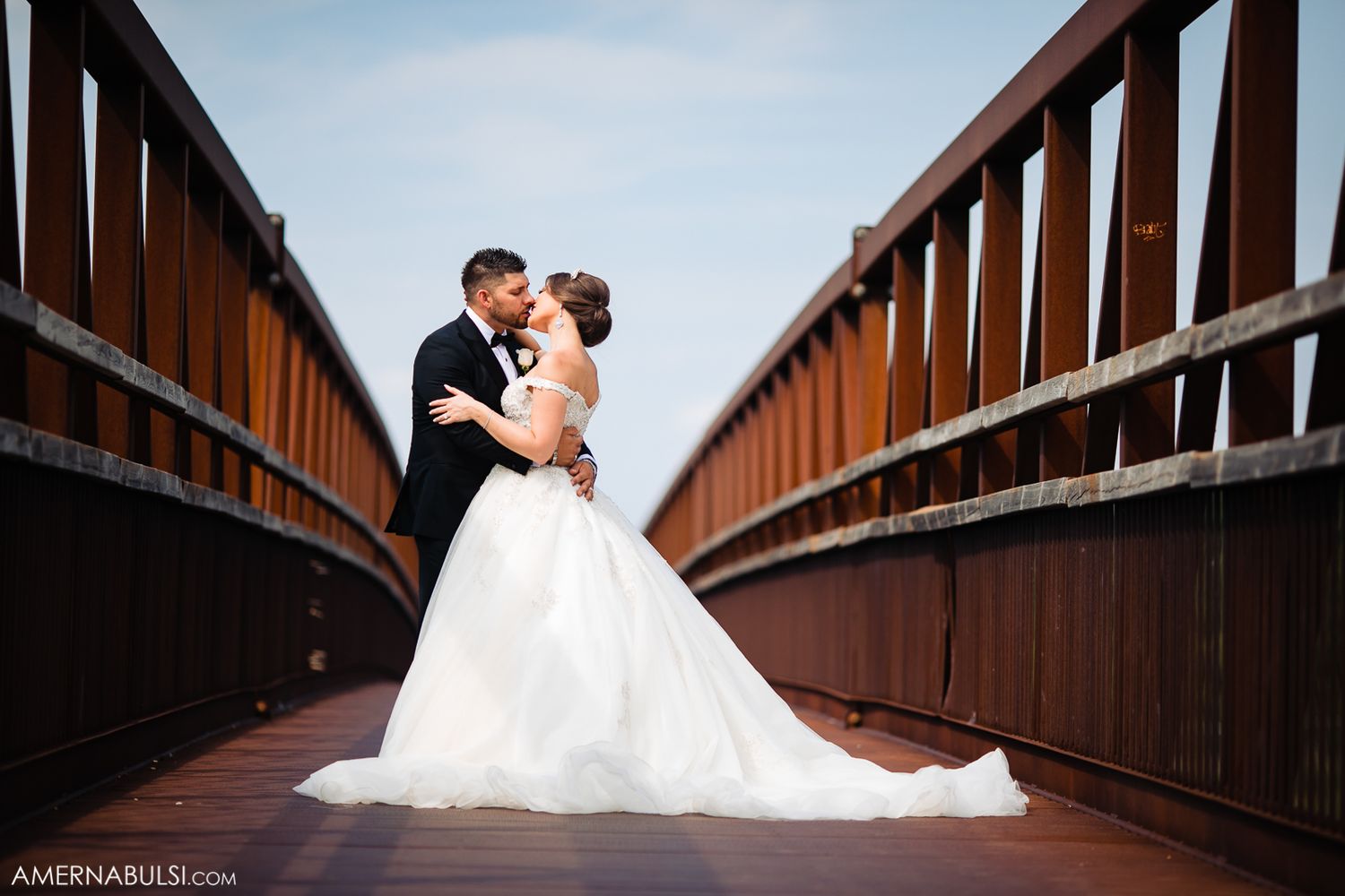 Romantic wedding couple shares intimate moments on a wooden bridge walkway during their photo session.