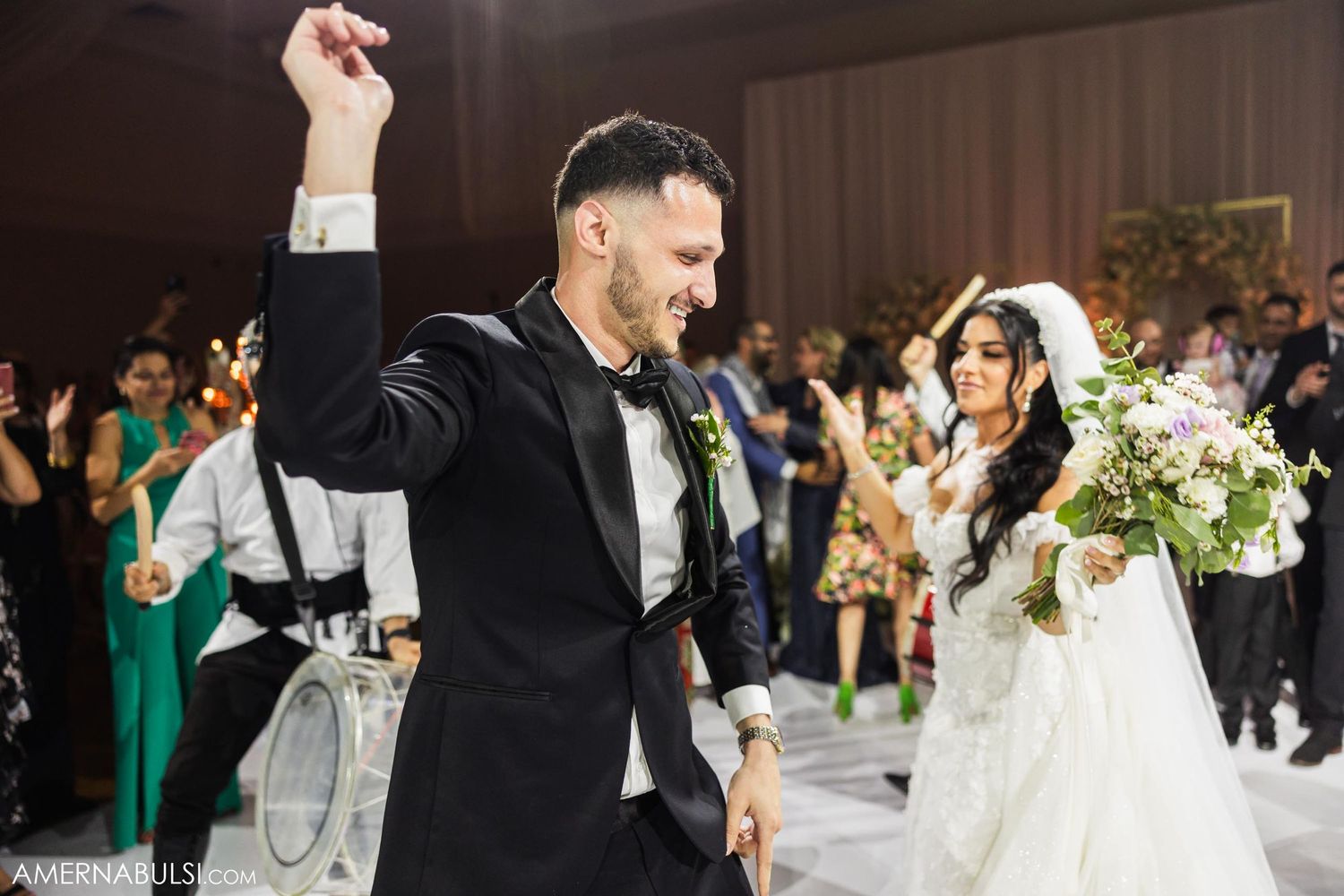 Wedding couple dancing joyfully during their reception celebration.