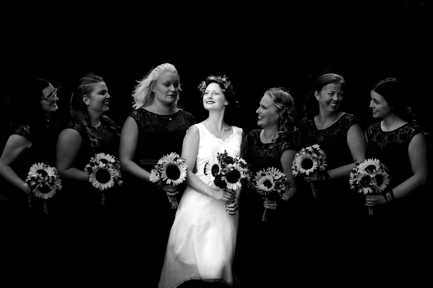 Dramatic black and white photo of wedding party with bouquets.