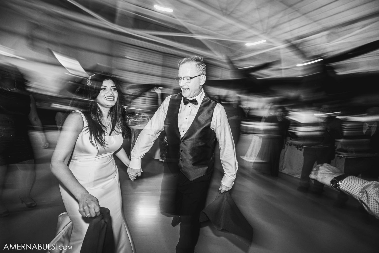 Black and white photo of wedding couple dancing with artistic motion blur effects.