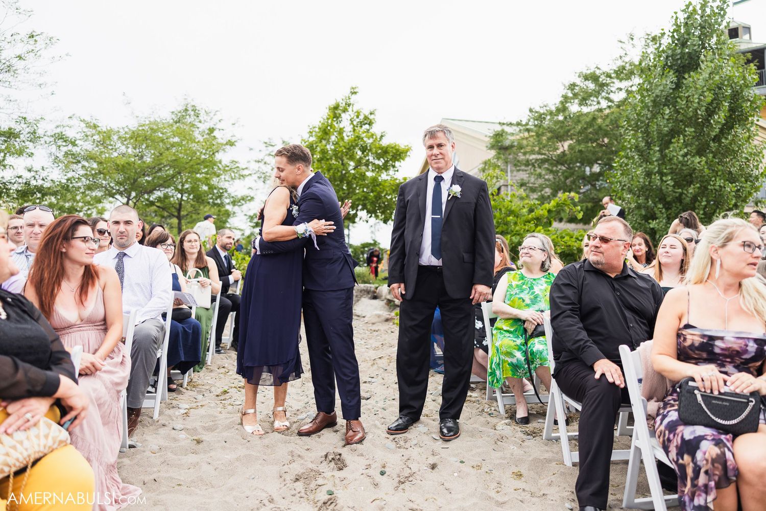 Wedding guests mingling at a casual outdoor beach reception.