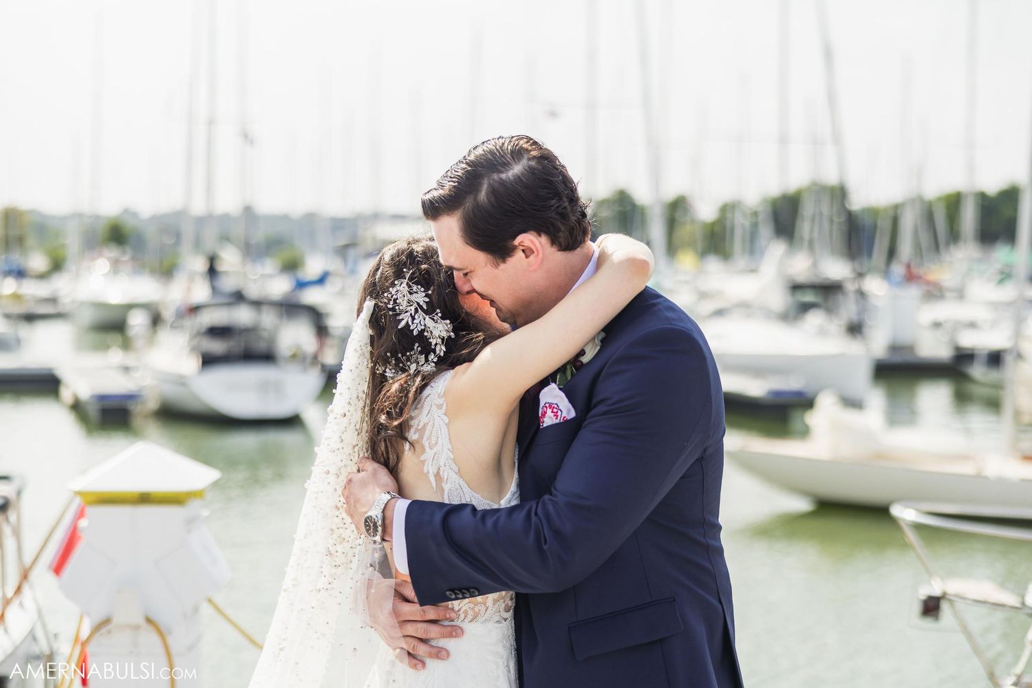 An emotional wedding moment shared between a couple on a marina dock.