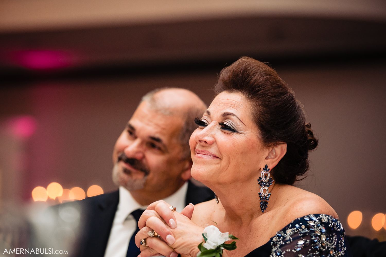 Elegant wedding reception celebration with warm lighting and chandelier in a ballroom setting.