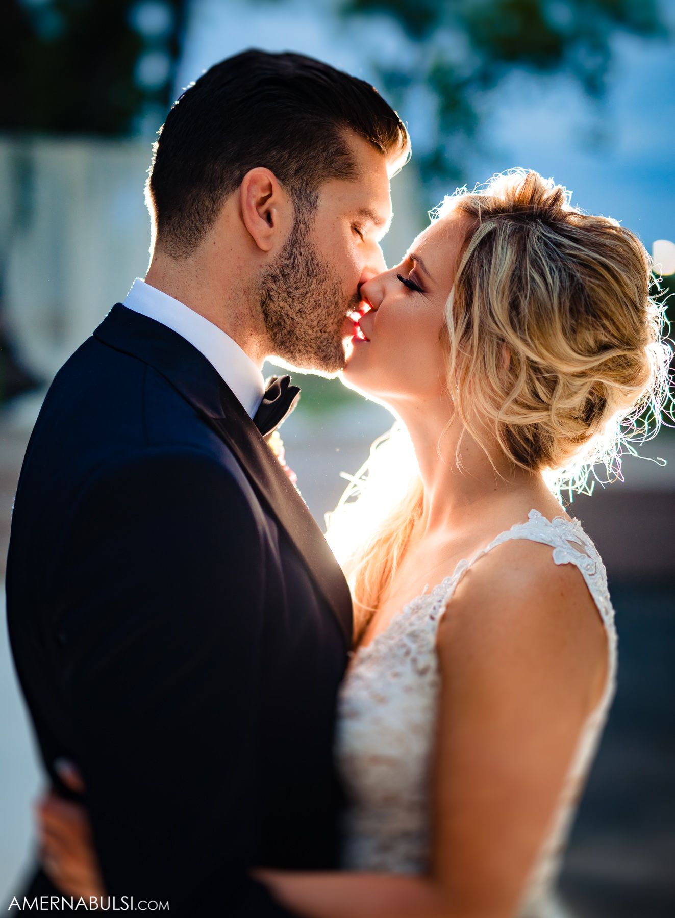 Romantic silhouetted couple sharing an intimate kiss at sunset with soft backlighting creating a dreamy atmosphere.