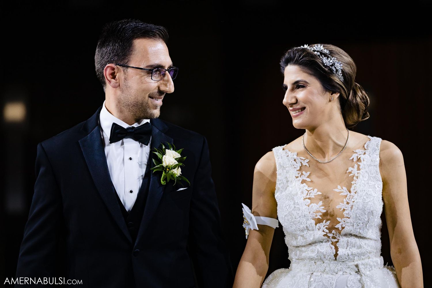 Candid moment between couple in formal wedding attire sharing joyful expression.