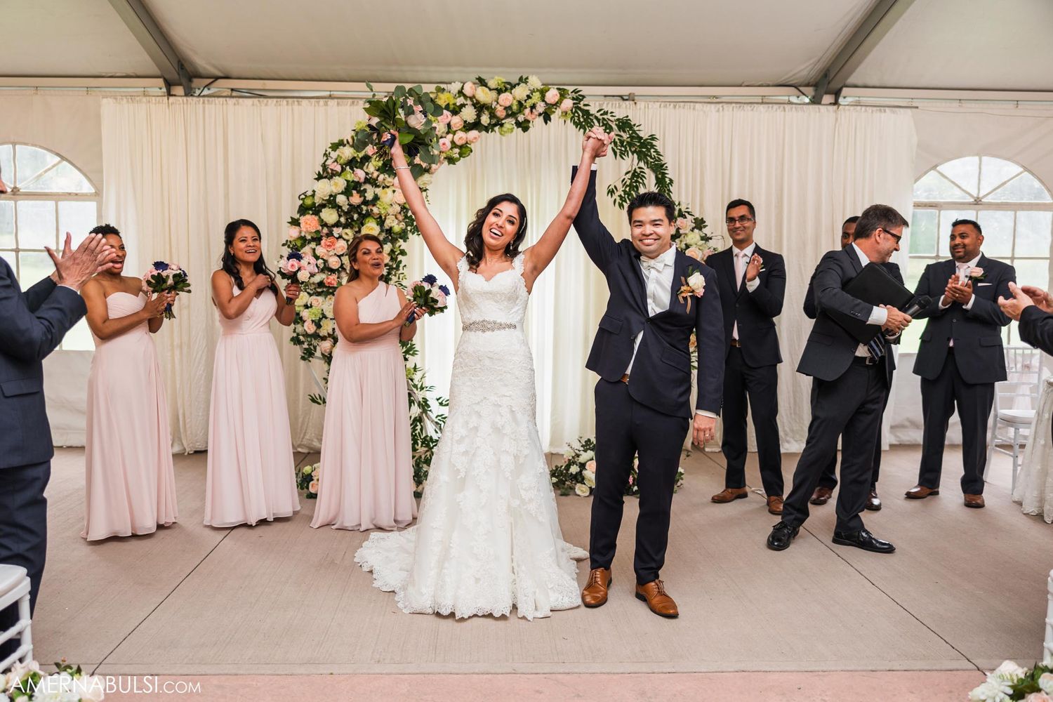 Newlyweds celebrate with their wedding party during a joyful reception entrance.