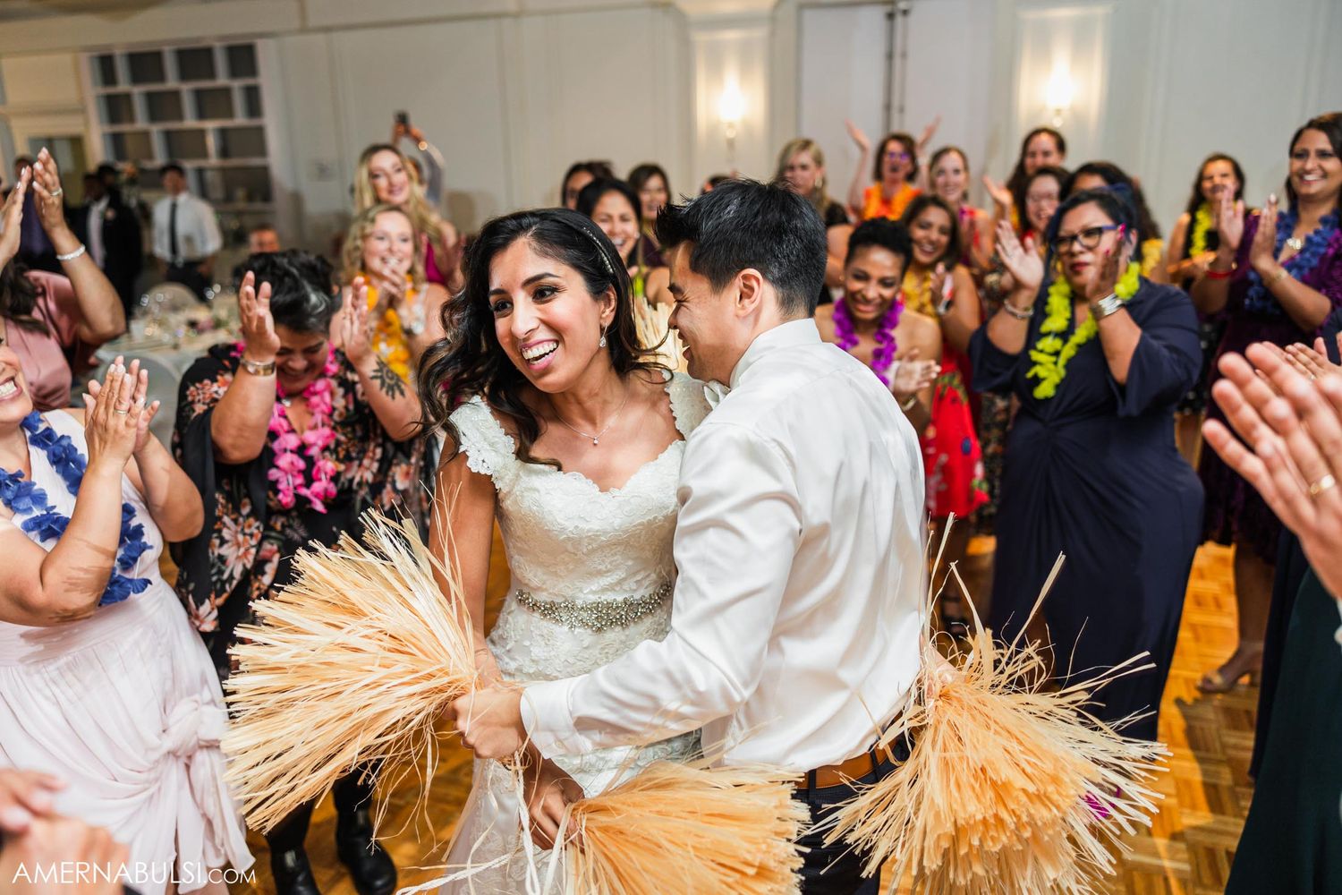 Wedding couple performs traditional dance with wheat stalks as guests cheer and celebrate.