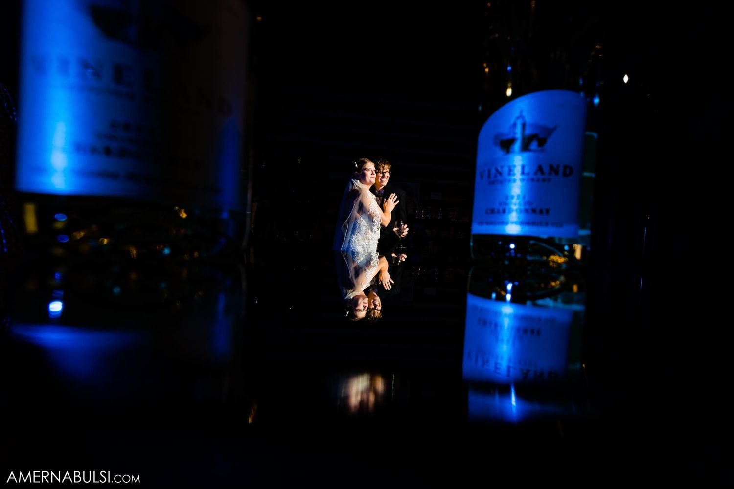 Dramatic silhouette dance moment with blue uplighting at wedding reception.