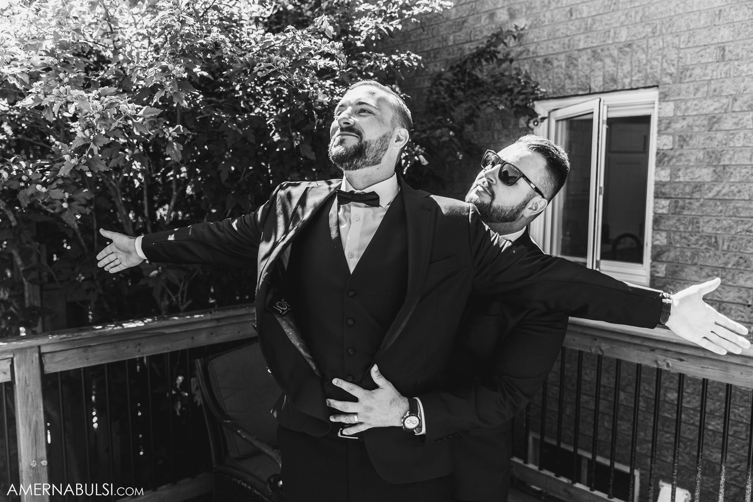 Two people in formal attire strike dramatic poses outdoors in black and white.