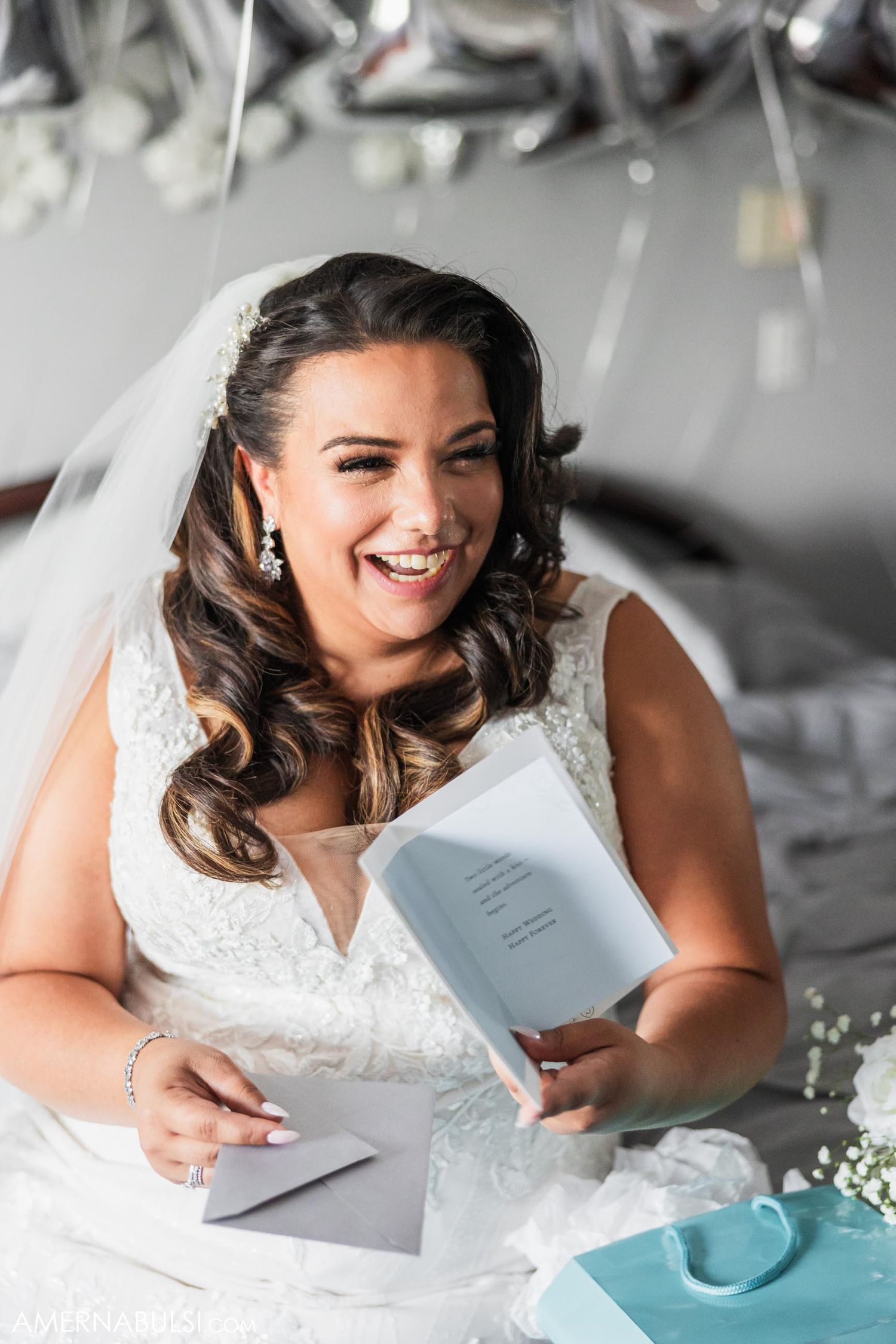 A person in a white dress sits reading a card surrounded by decorative elements.