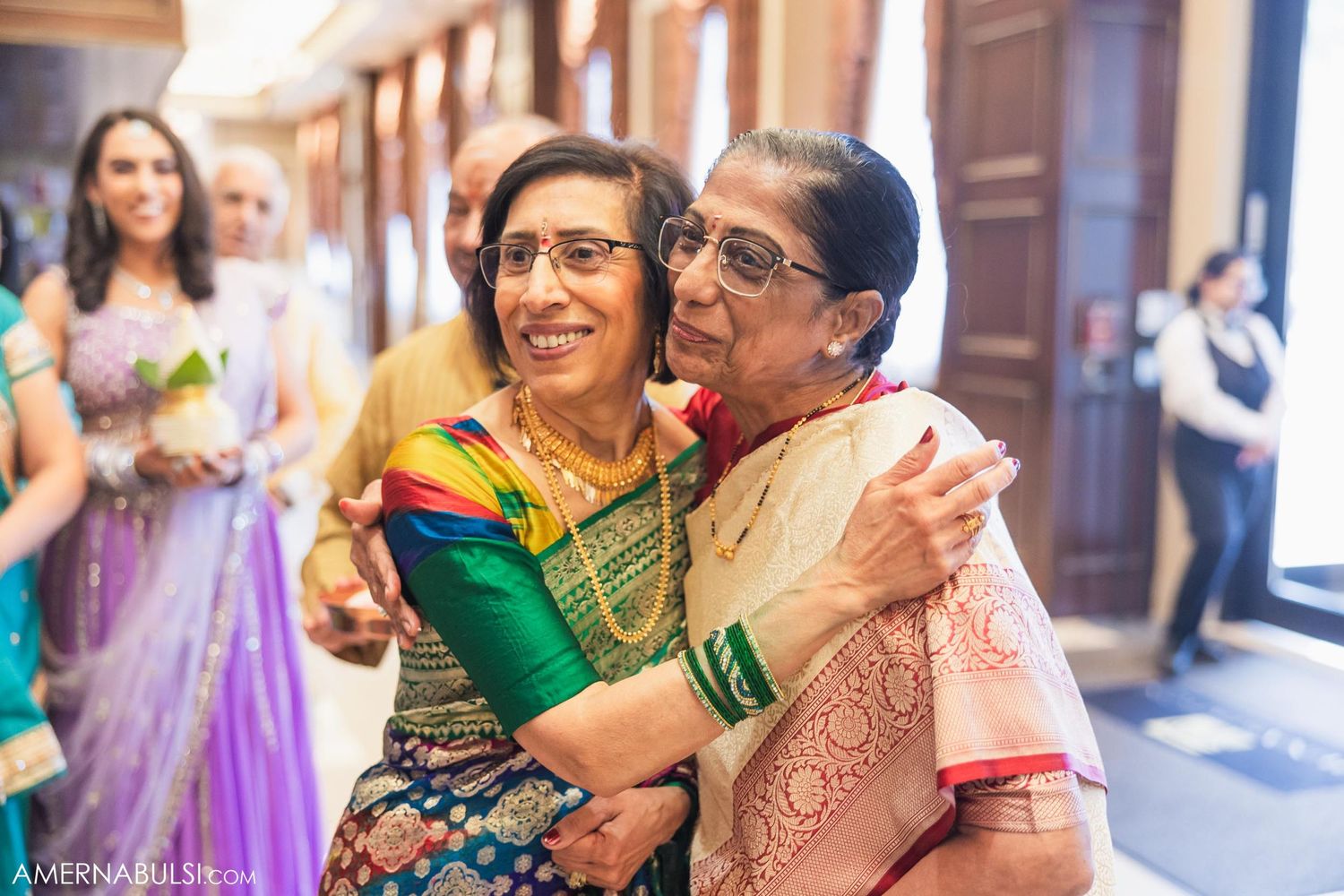 Guests celebrating at an Indian wedding wearing traditional colorful sarees.