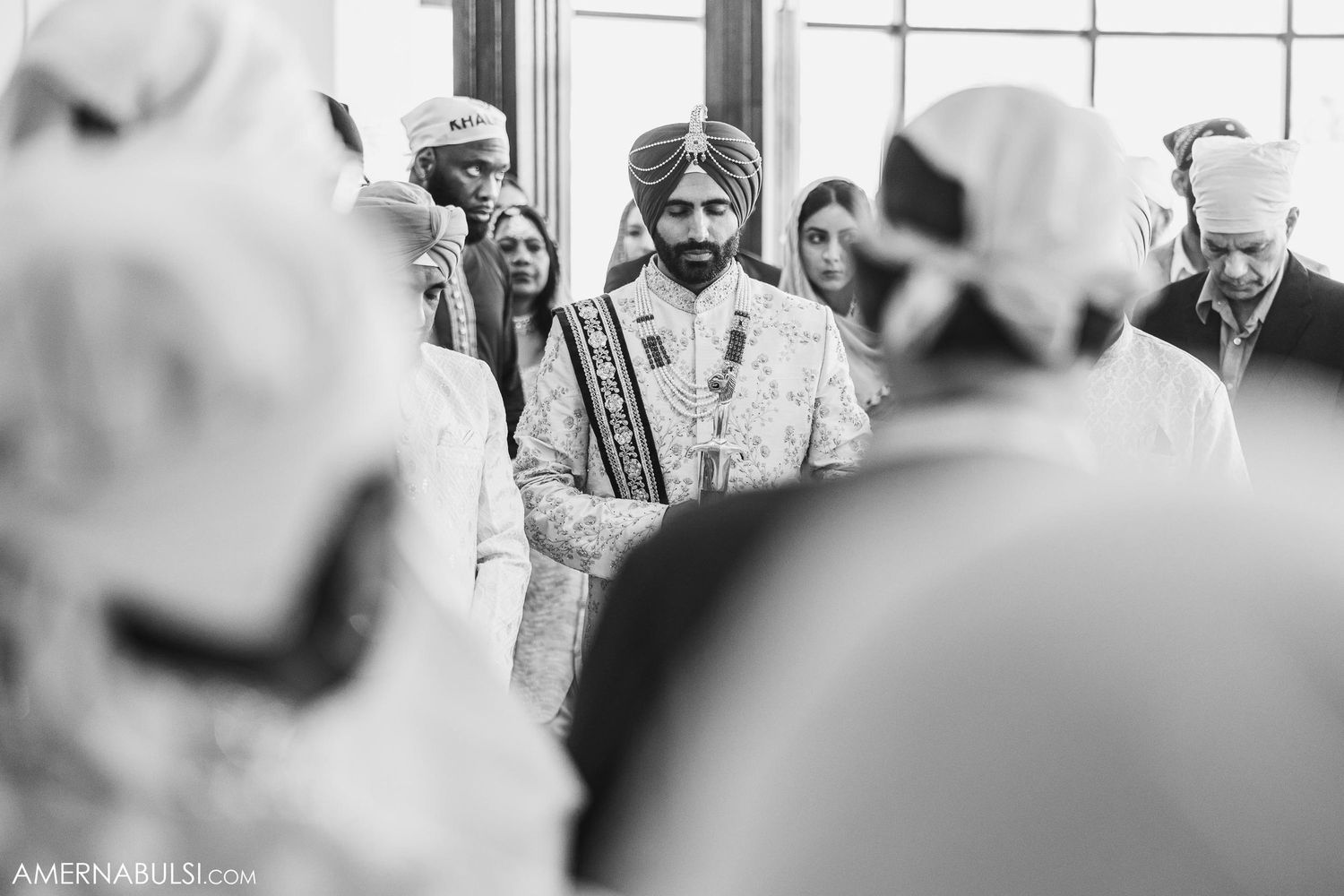 A traditional Sikh wedding ceremony with guests gathering in traditional attire during an indoor celebration.