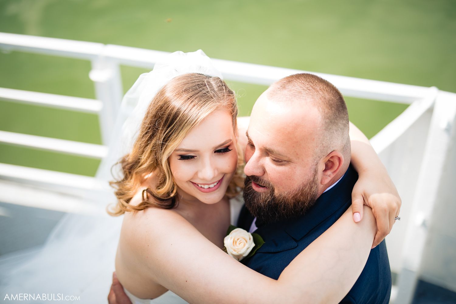 Romantic outdoor wedding portraits on a sunny day with green background.