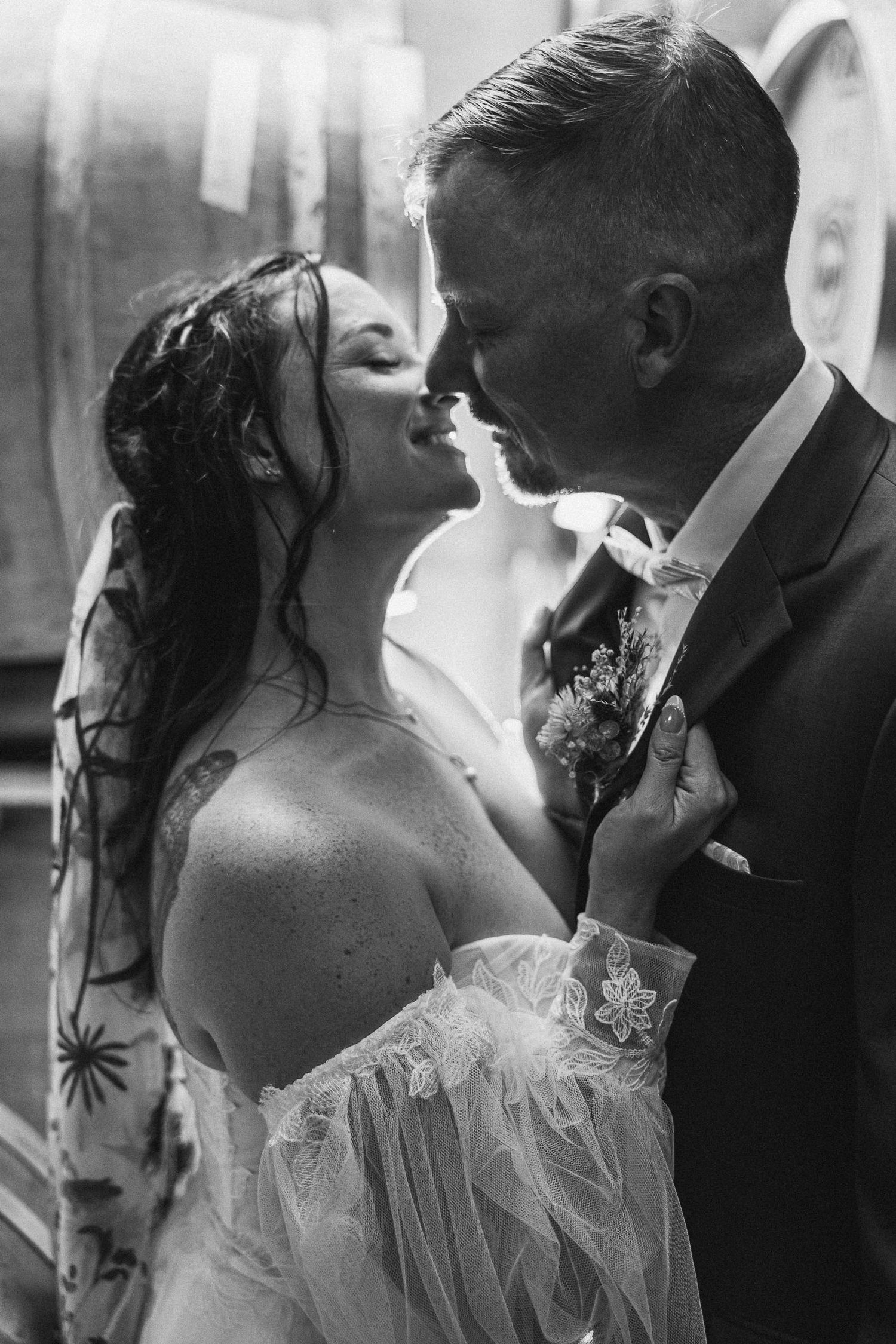 Romantic black and white portrait of newlyweds sharing intimate moment.