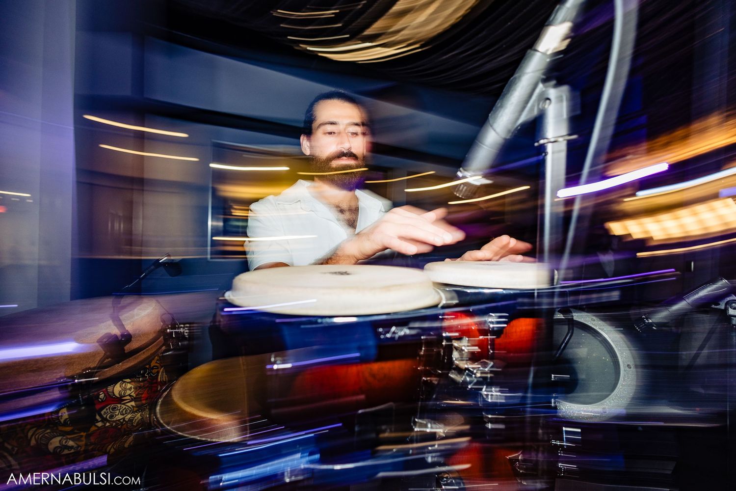DJ performing at a nightclub with turntables and colorful lighting effects in motion blur.