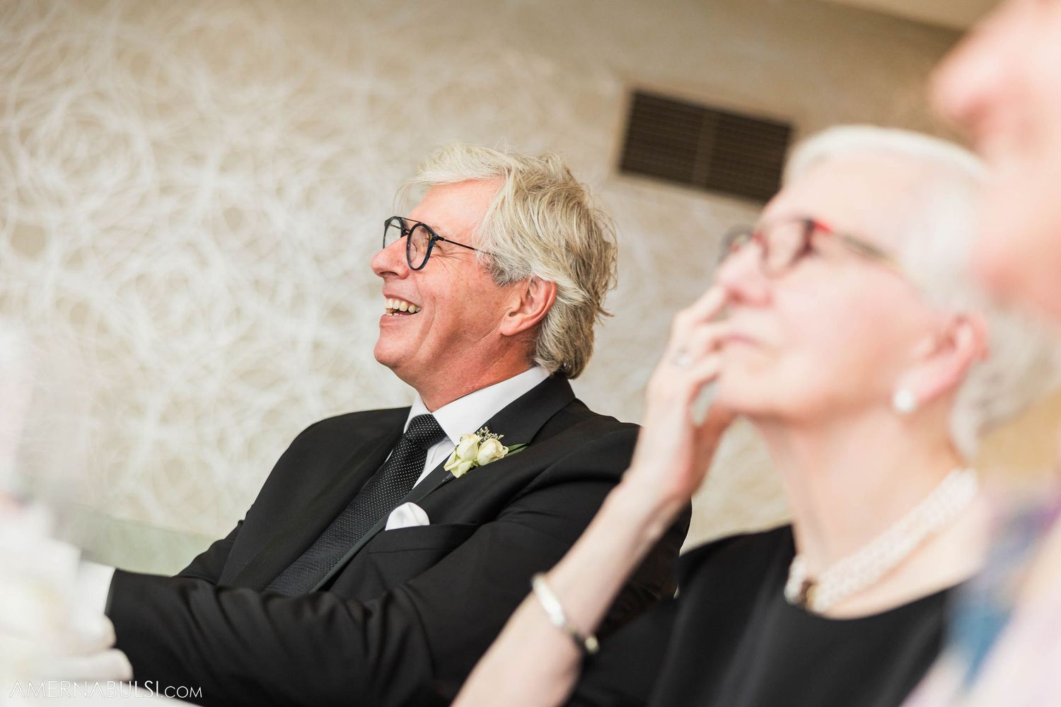 Two guests enjoying and laughing during formal dinner event.