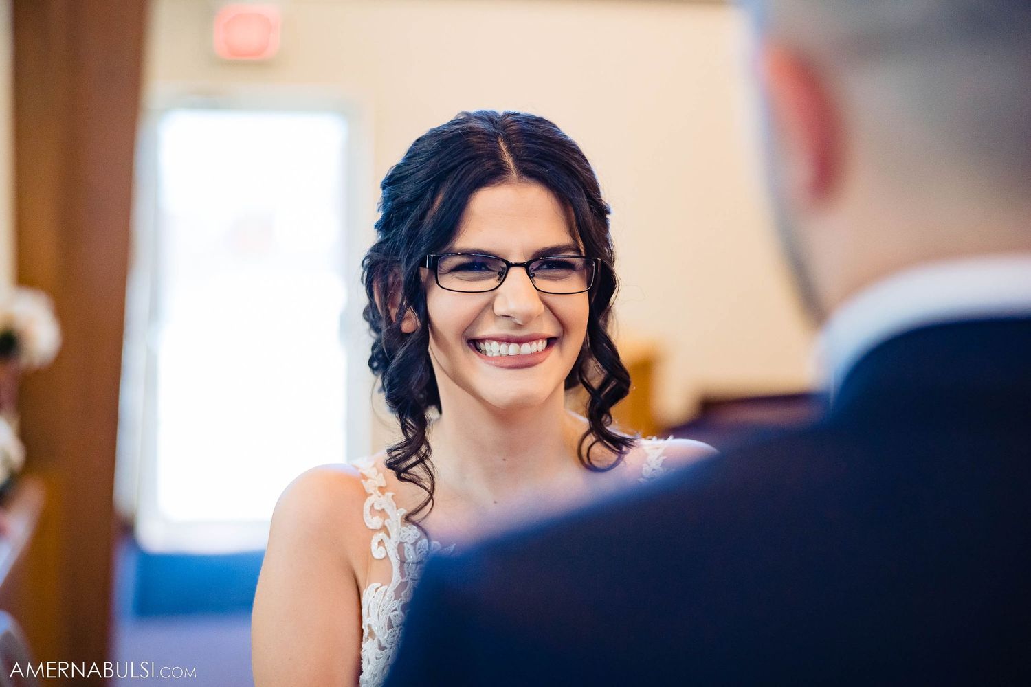 Indoor wedding ceremony portrait with natural window lighting.