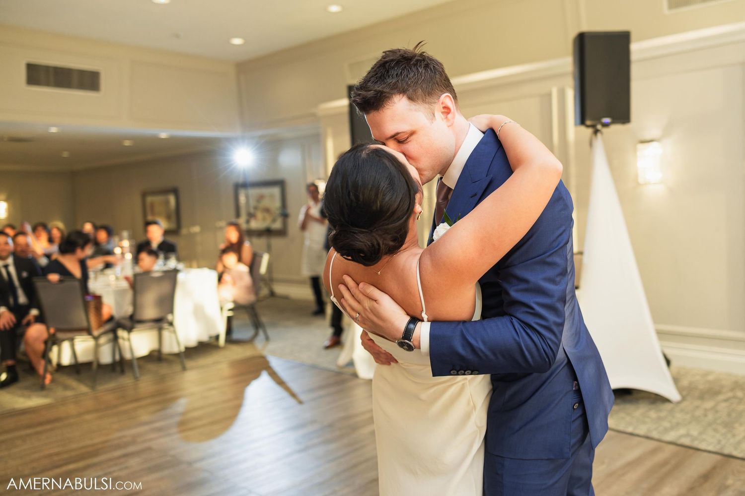 A couple shares their first dance in an elegant reception hall.