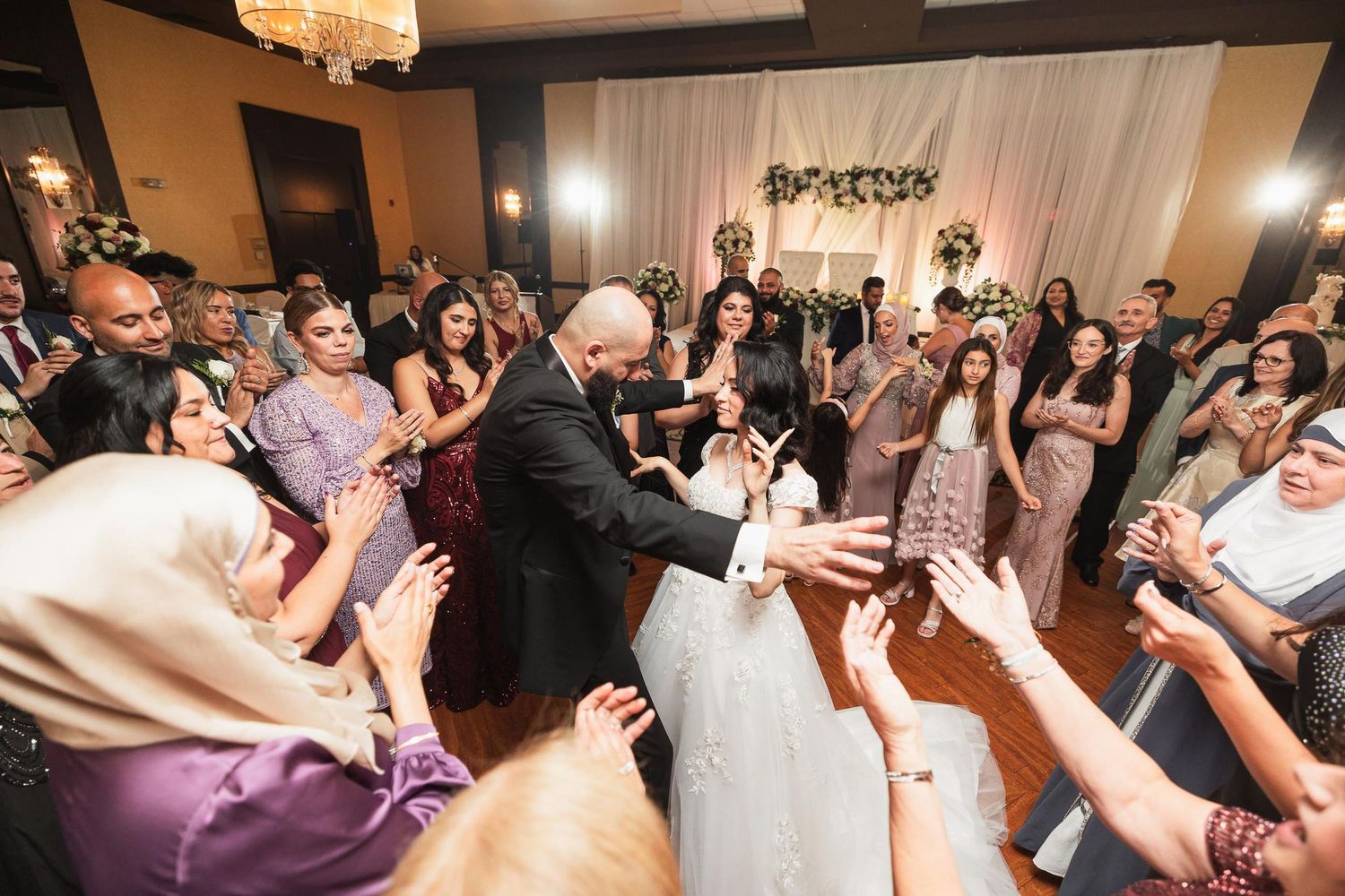 Wedding reception dance party with sparklers and guests celebrating.