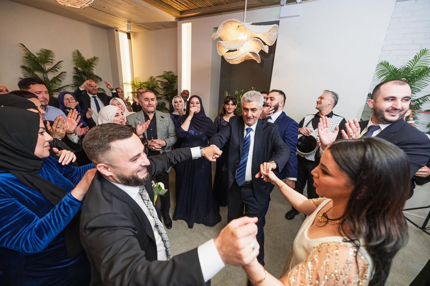 Lively wedding reception celebration with guests dancing and cheering.