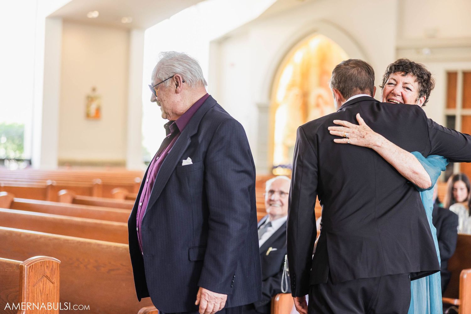 Emotional moment captured during wedding ceremony in church pews.