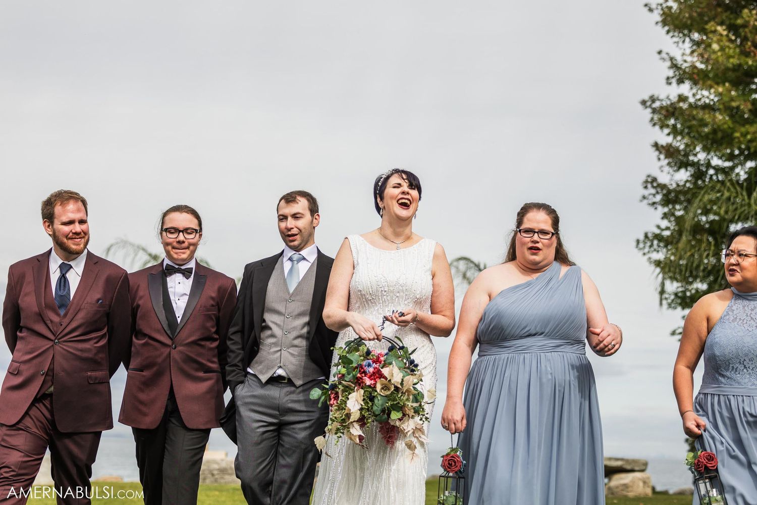 Wedding party poses together outdoors with bridal party in grey attire.