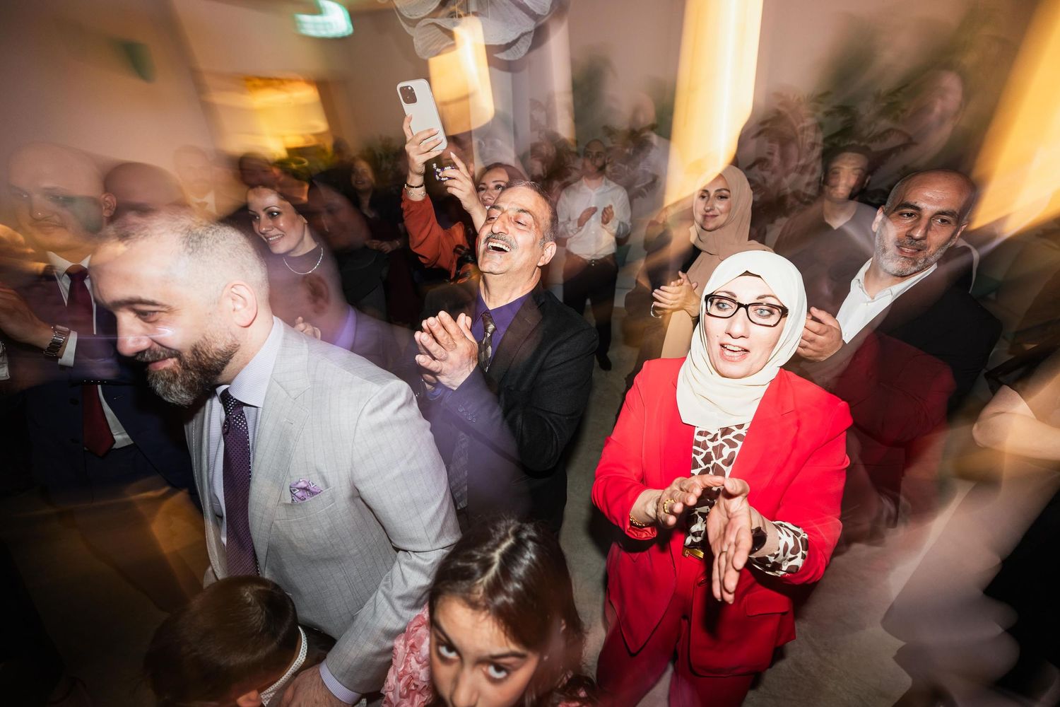 Guests dancing and celebrating with motion blur at a lively indoor party.