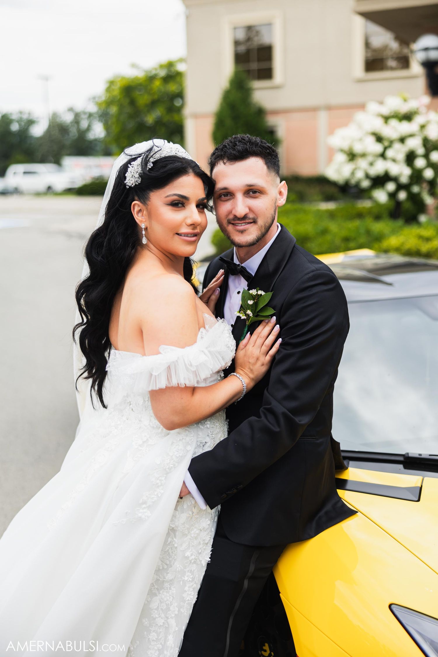 Elegant wedding couple posing beside a yellow sports car on their special day.