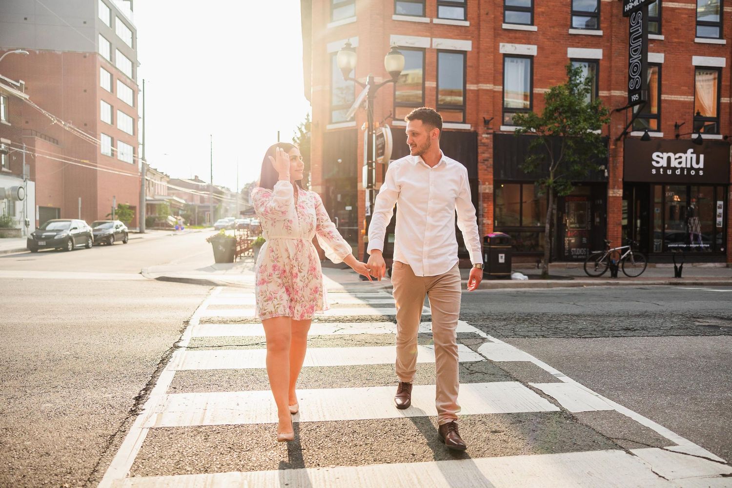 Sun-drenched urban crosswalk scene with brick buildings and summer style.
