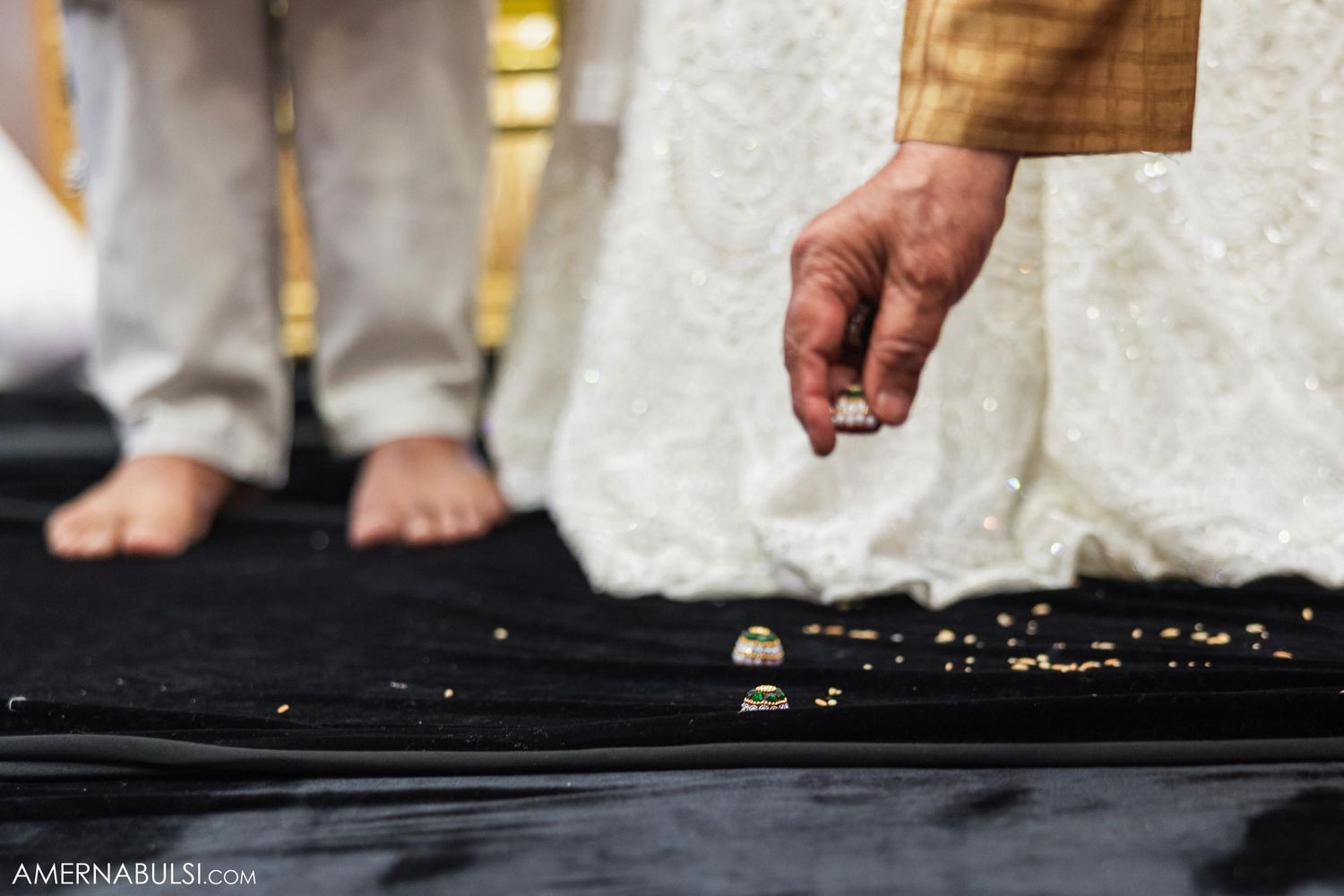 Close-up of hand scattering ceremonial items during traditional Indian wedding ritual.