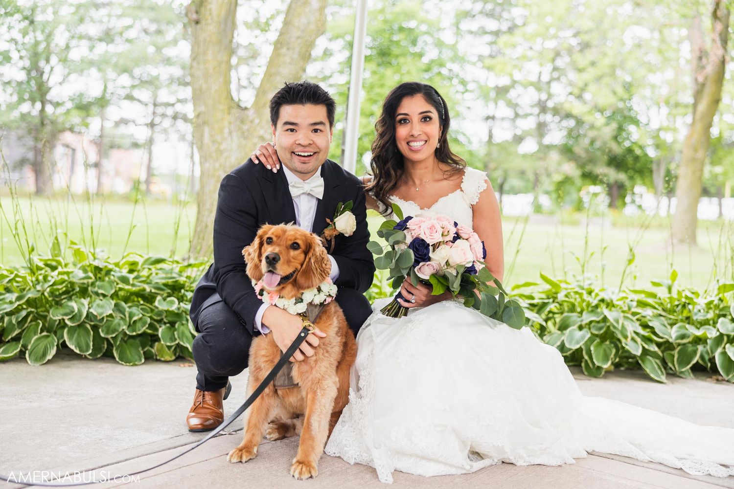 Outdoor wedding portrait featuring couple and their golden retriever dog on a garden swing.