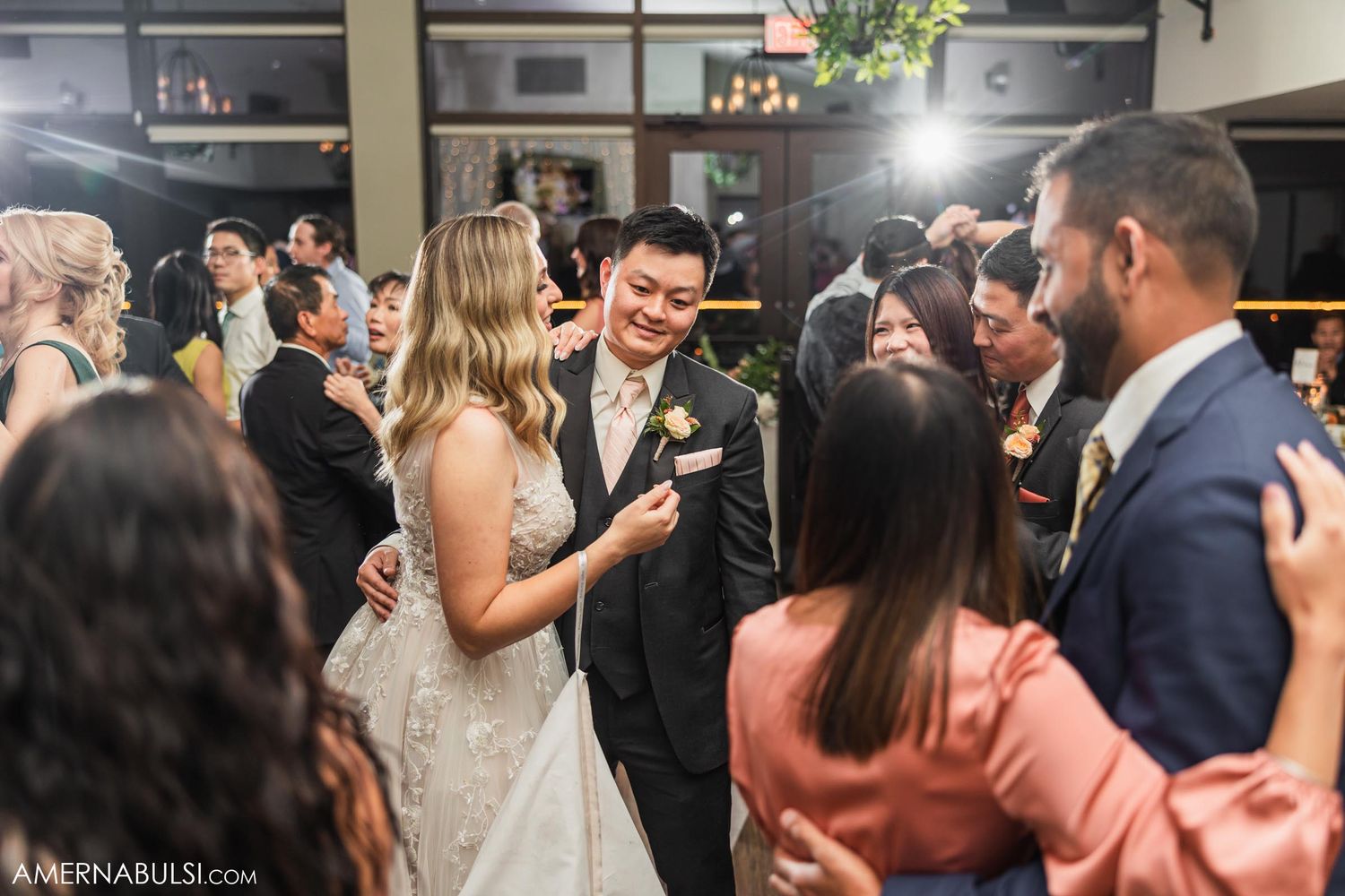 Wedding guests surround the happy couple during reception celebrations.