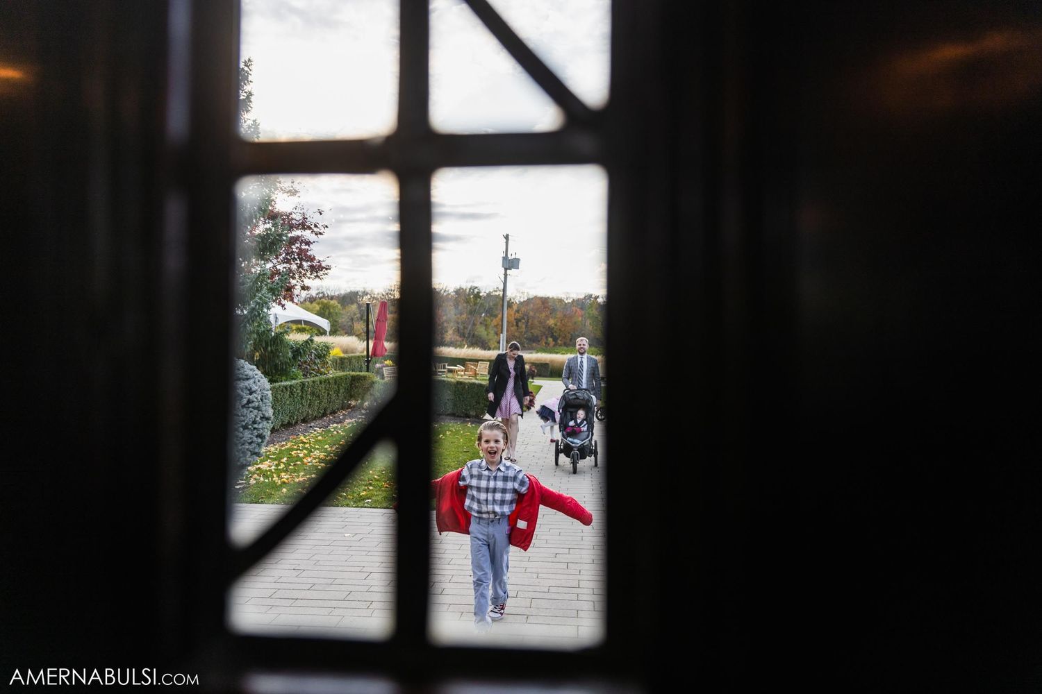 View through window of people walking outside on autumn day.