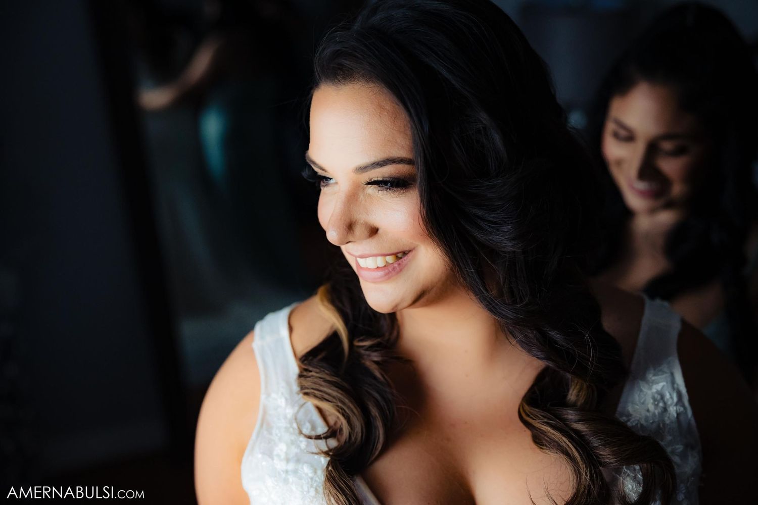 Wedding preparation moment showing elegant bridal hair styling and lace dress detail.