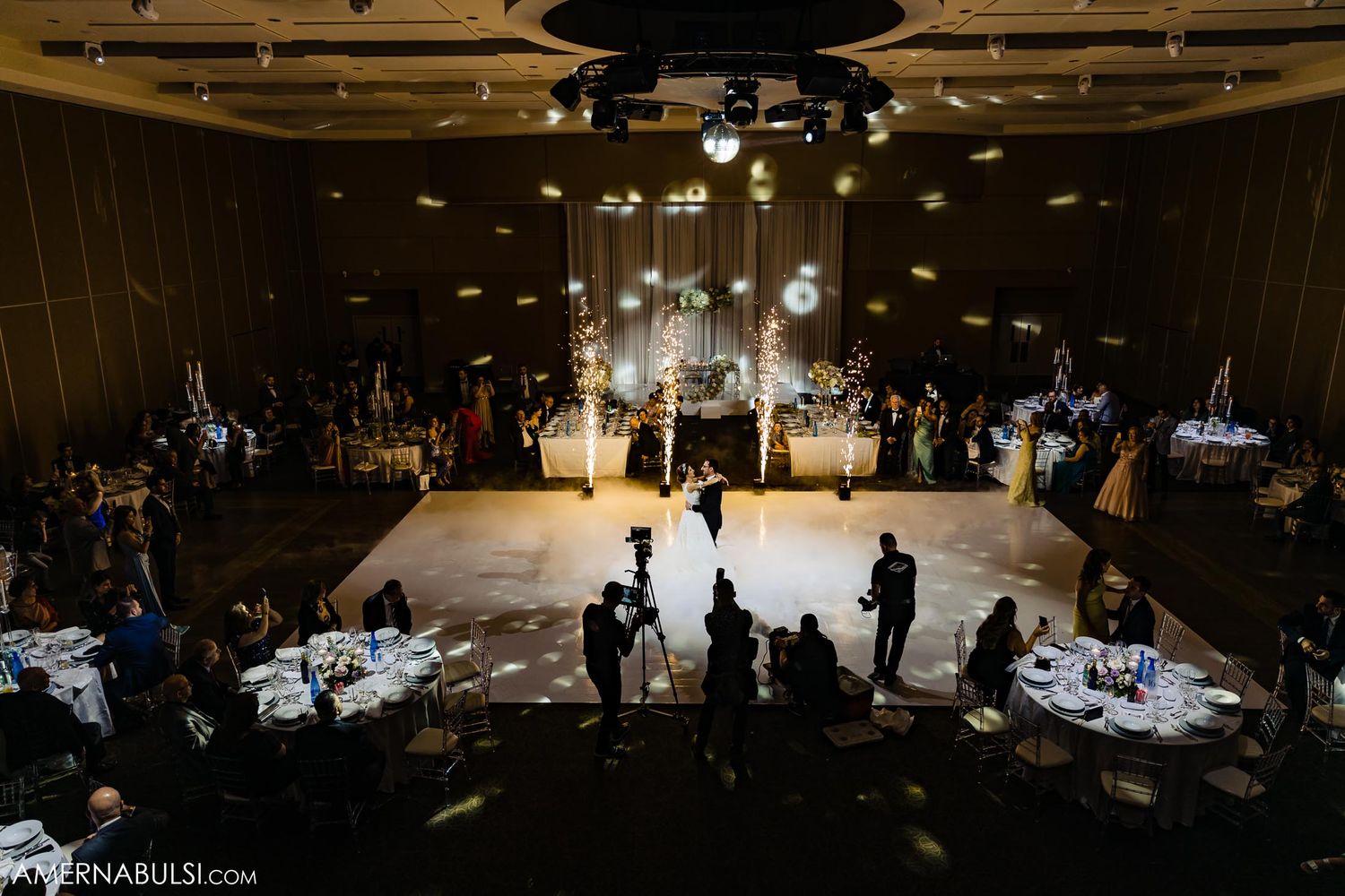 Wedding reception venue with dramatic lighting and fog effects on the dance floor.