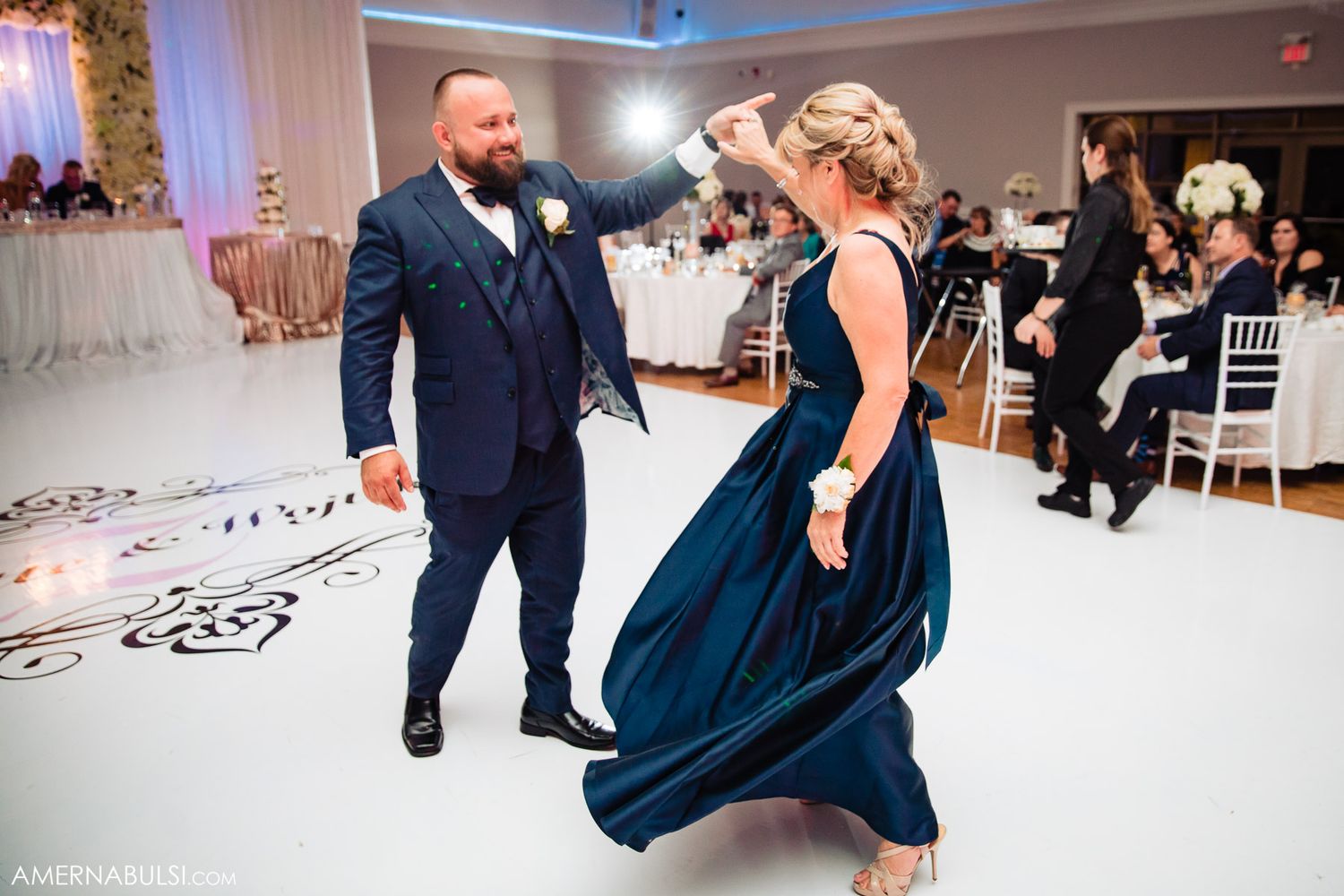 Couples dancing together at an elegant wedding reception in a beautifully decorated ballroom.