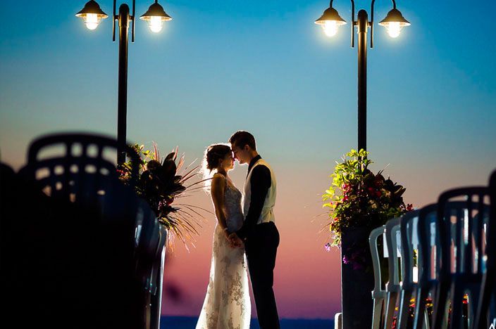 Romantic sunset wedding portraits with glowing lanterns and waterfront views.