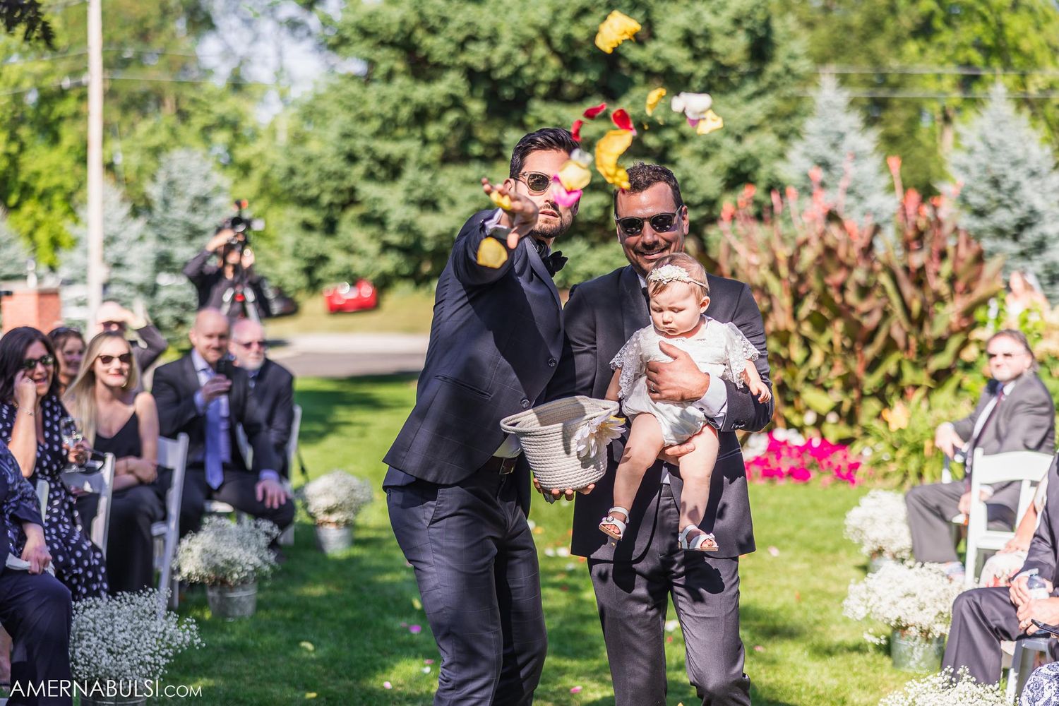 Joyful celebration moment at outdoor wedding ceremony with guests in background.