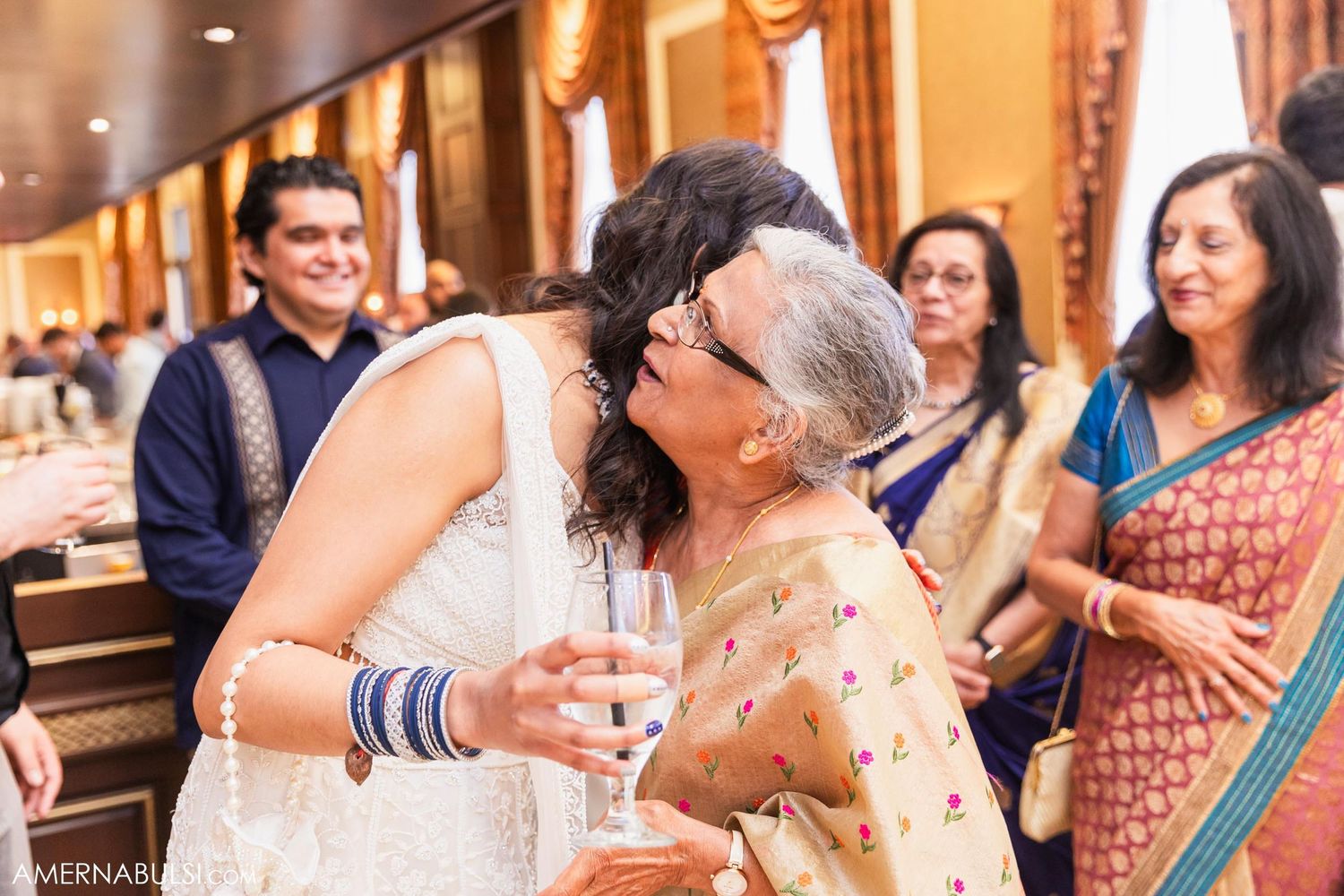 Two people share an emotional embrace during a traditional Indian wedding ceremony celebration.