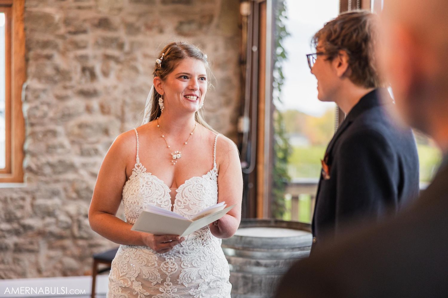 A wedding ceremony moment captured in a rustic stone venue with natural lighting.