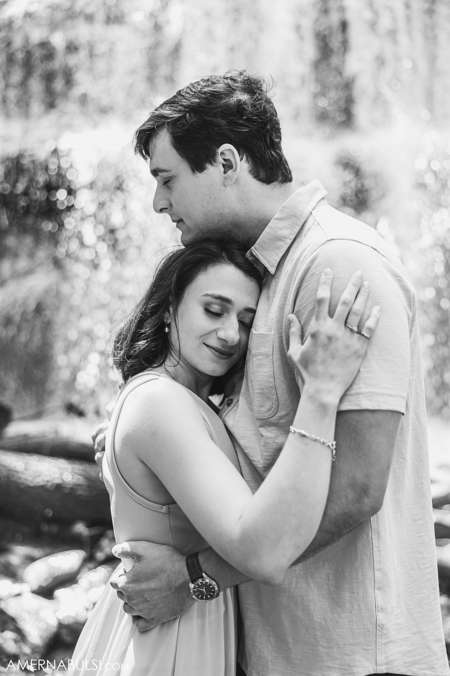 Black and white portrait of an intimate embrace with a waterfall backdrop.