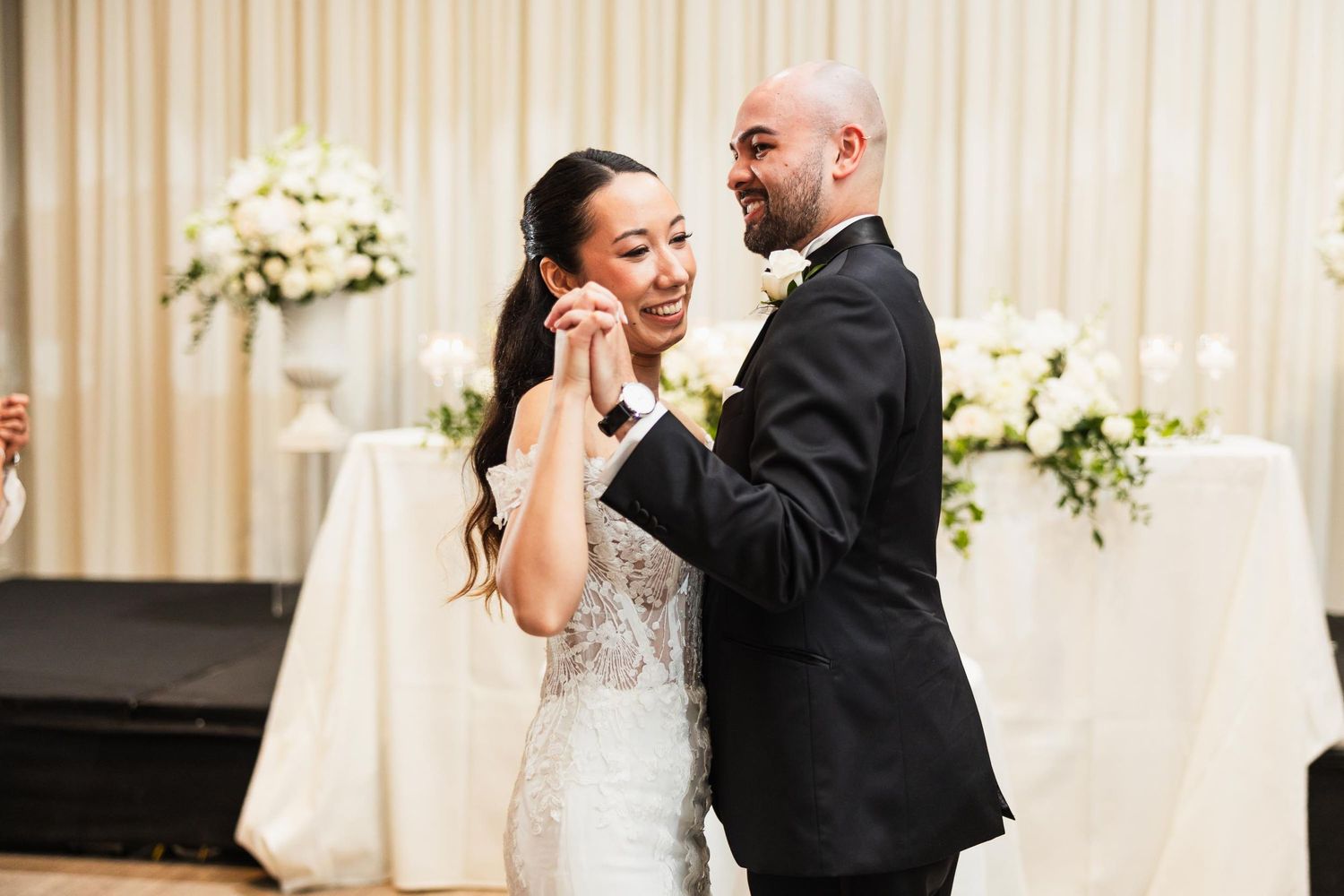 A couple shares an intimate moment during their first dance at an elegant wedding reception.