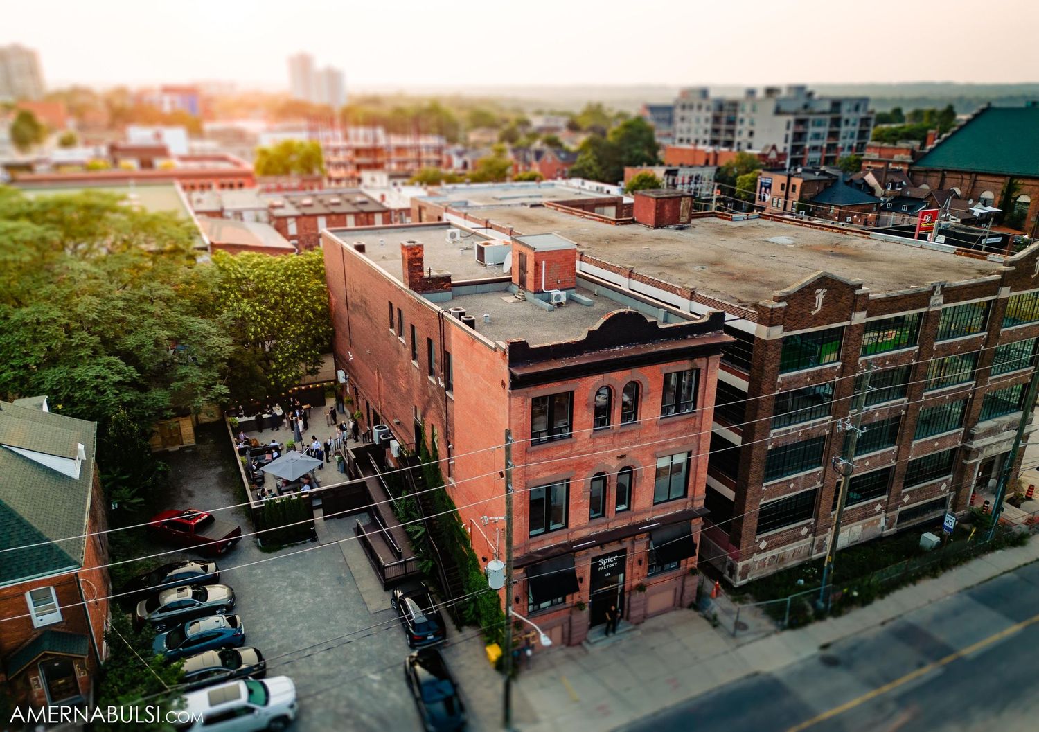 Aerial view of brick buildings and urban architecture in a city neighborhood at sunset.
